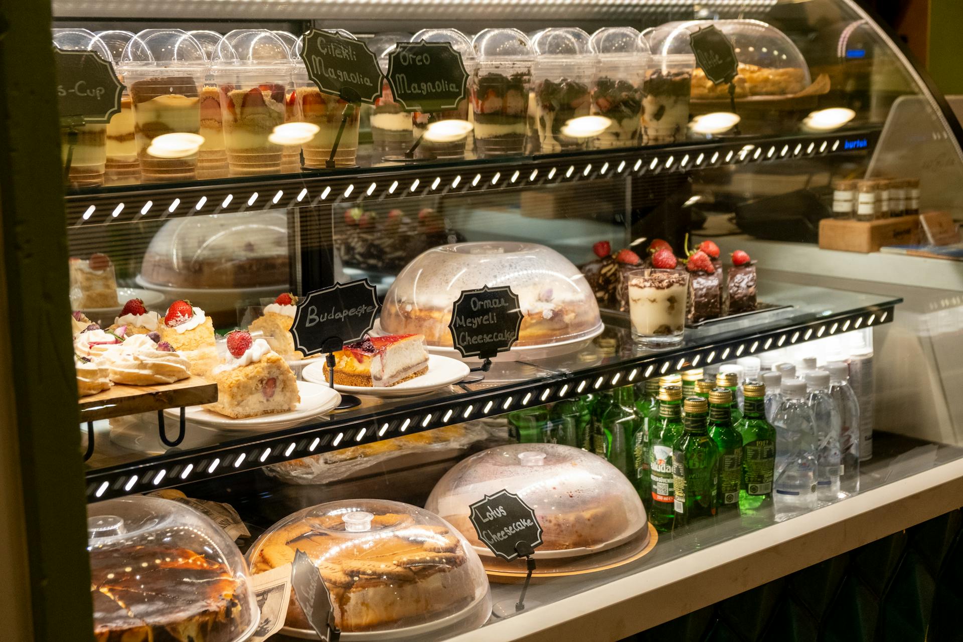 Delicious assortment of cakes and desserts displayed in a bakery case for customers.