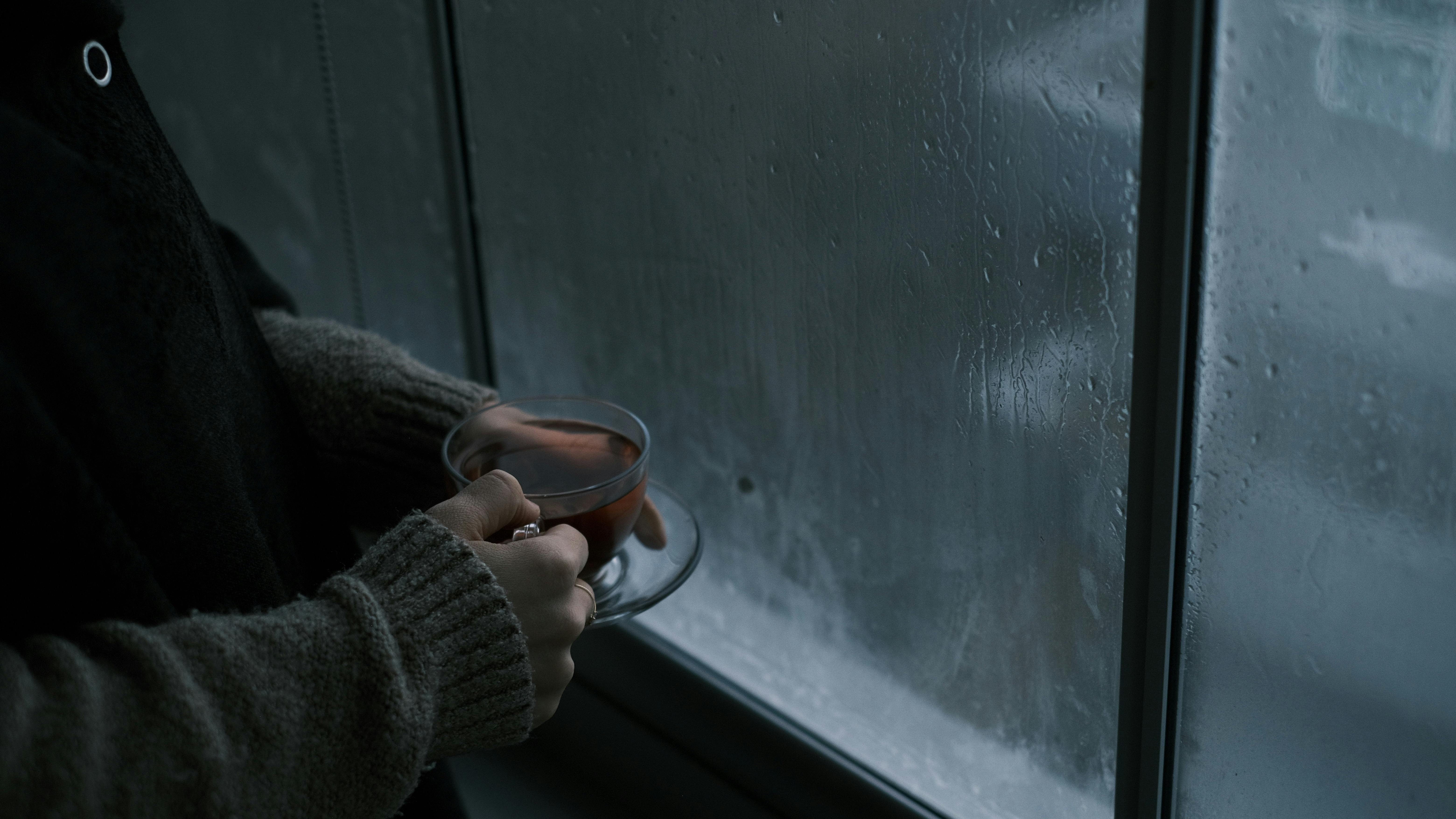 A caregiver taking a quiet, reflective moment with a cup of tea by a window - Nurturing caregiver well-being