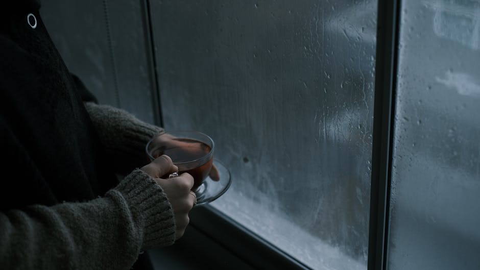 A caregiver taking a quiet, reflective moment with a cup of tea by a window - Nurturing caregiver well-being