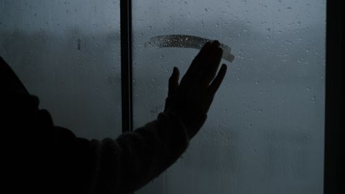 Free A hand touching a rainy, steamy window creating a melancholic indoor atmosphere. Stock Photo