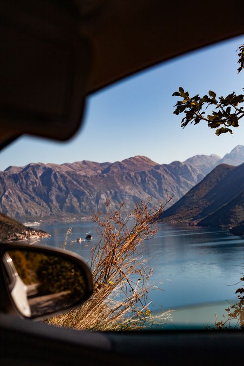 Free Stunning view of a tranquil mountain lake framed by car window, capturing serenity of nature. Stock Photo