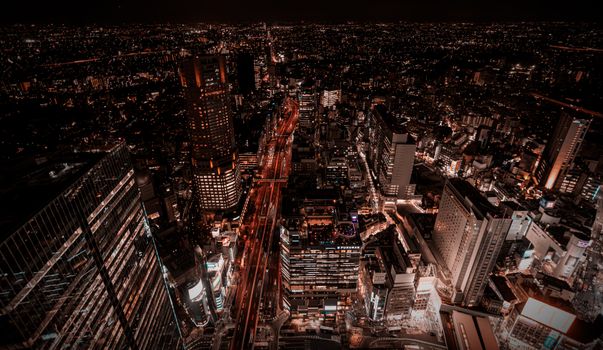 Stunning aerial view of Tokyo's vibrant cityscape at night featuring illuminated skyscrapers and bustling streets.