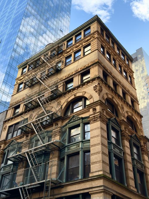 Free A classic urban building facade with ornate details and fire escape. Stock Photo