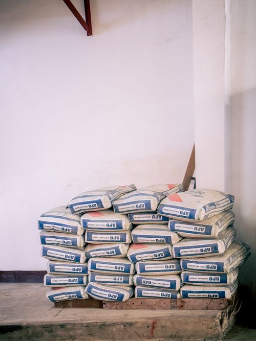 Free A stack of bags of cement neatly arranged in an indoor warehouse environment. Stock Photo