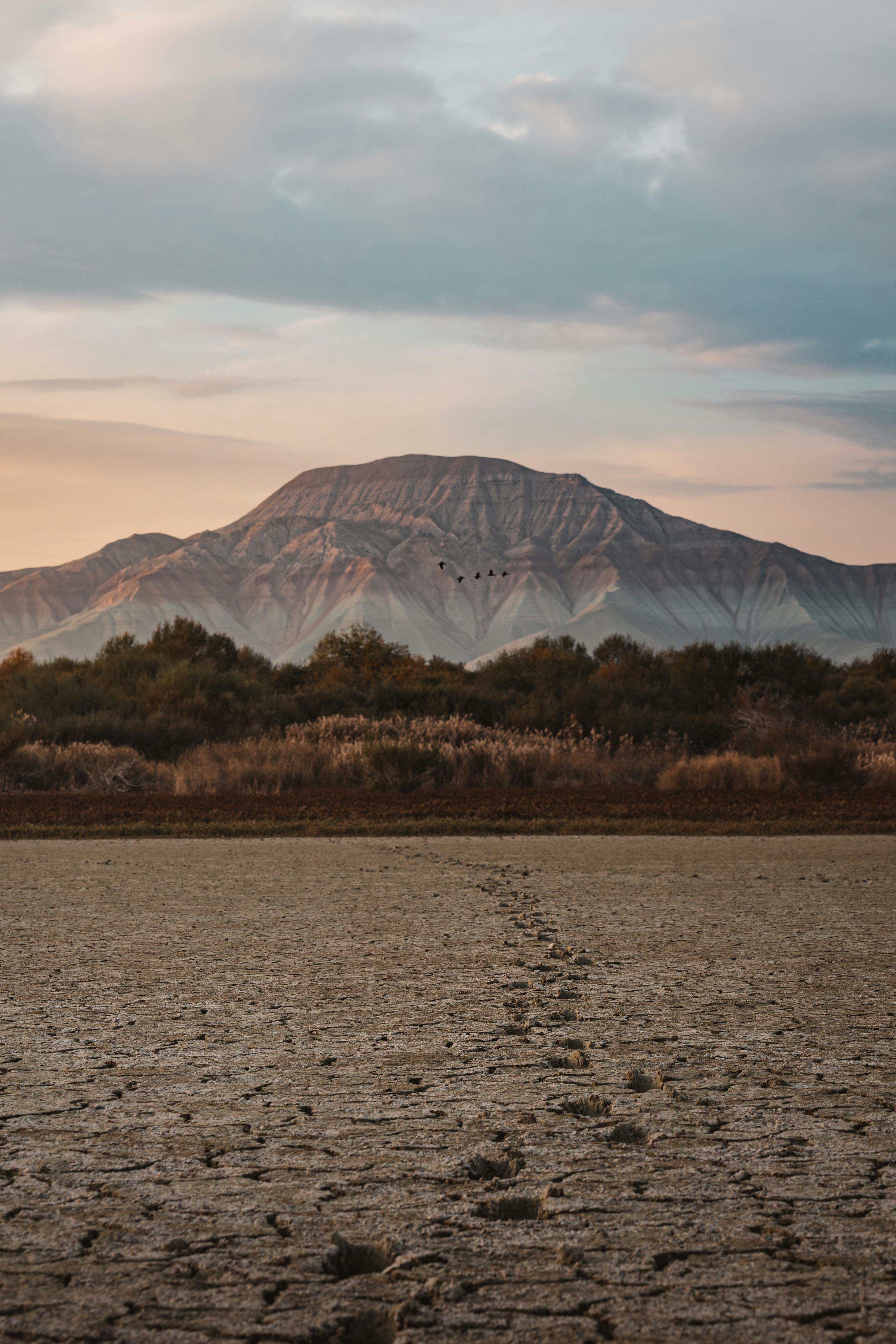 A tranquil landscape featuring a distant mountain under a picturesque sunset sky, creating a serene and mystical aura in Ankara, Türkiye.