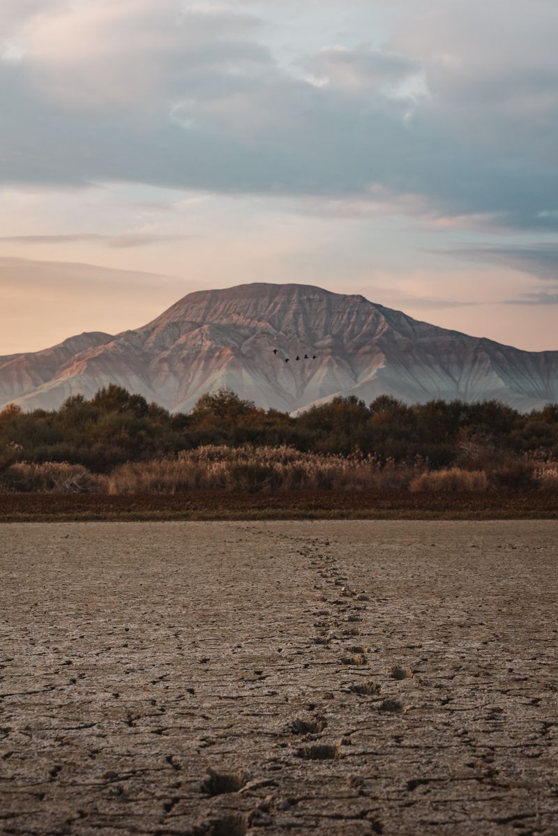 A tranquil landscape featuring a distant mountain under a picturesque sunset sky, creating a serene and mystical aura in Ankara, Türkiye.