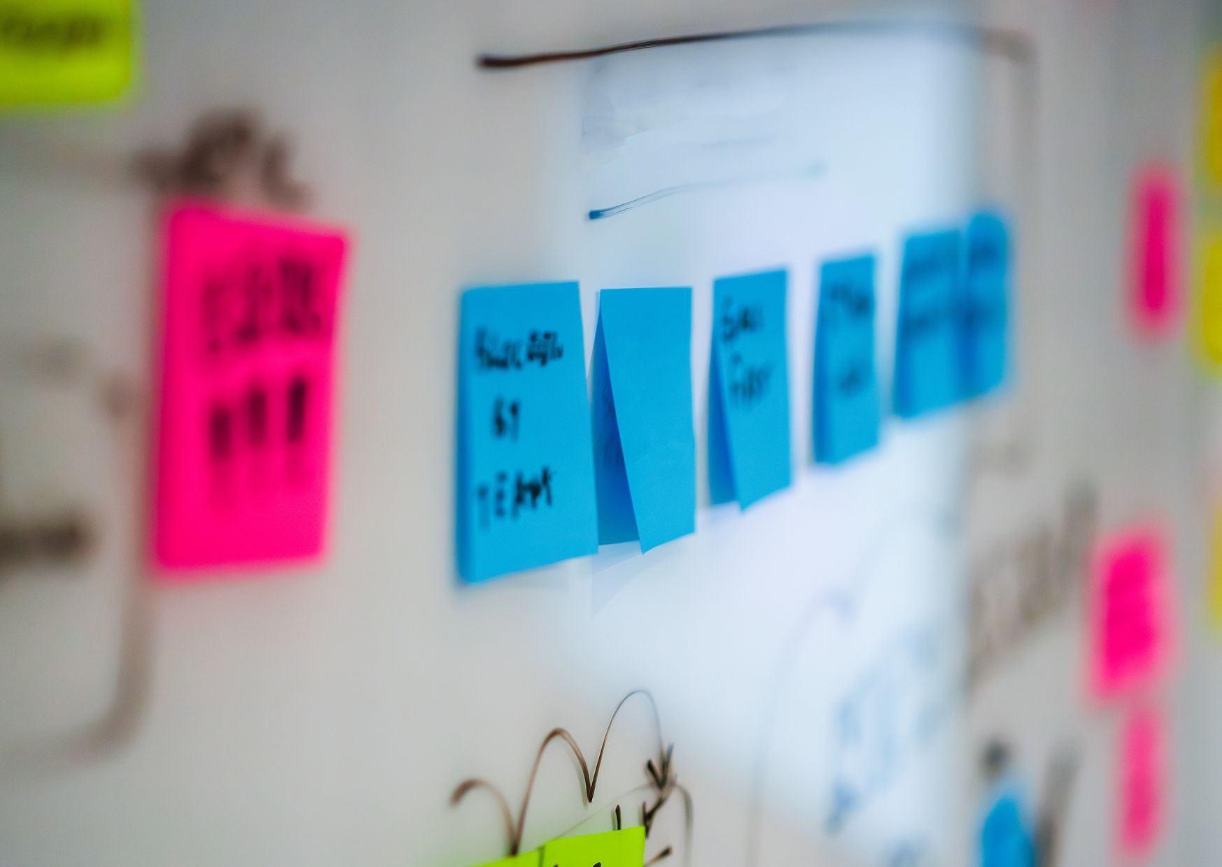 Équipe en atelier de brainstorming avec post-it sur un tableau blanc