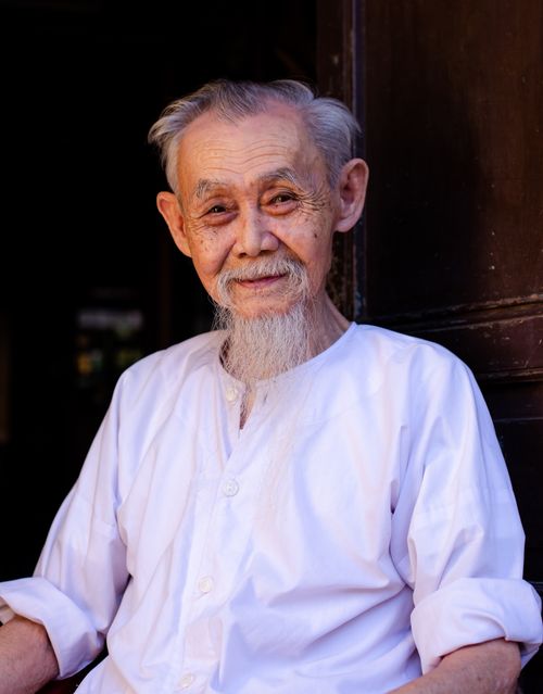 Free Elderly Vietnamese man in Hội An, smiling warmly in a traditional white shirt. Stock Photo