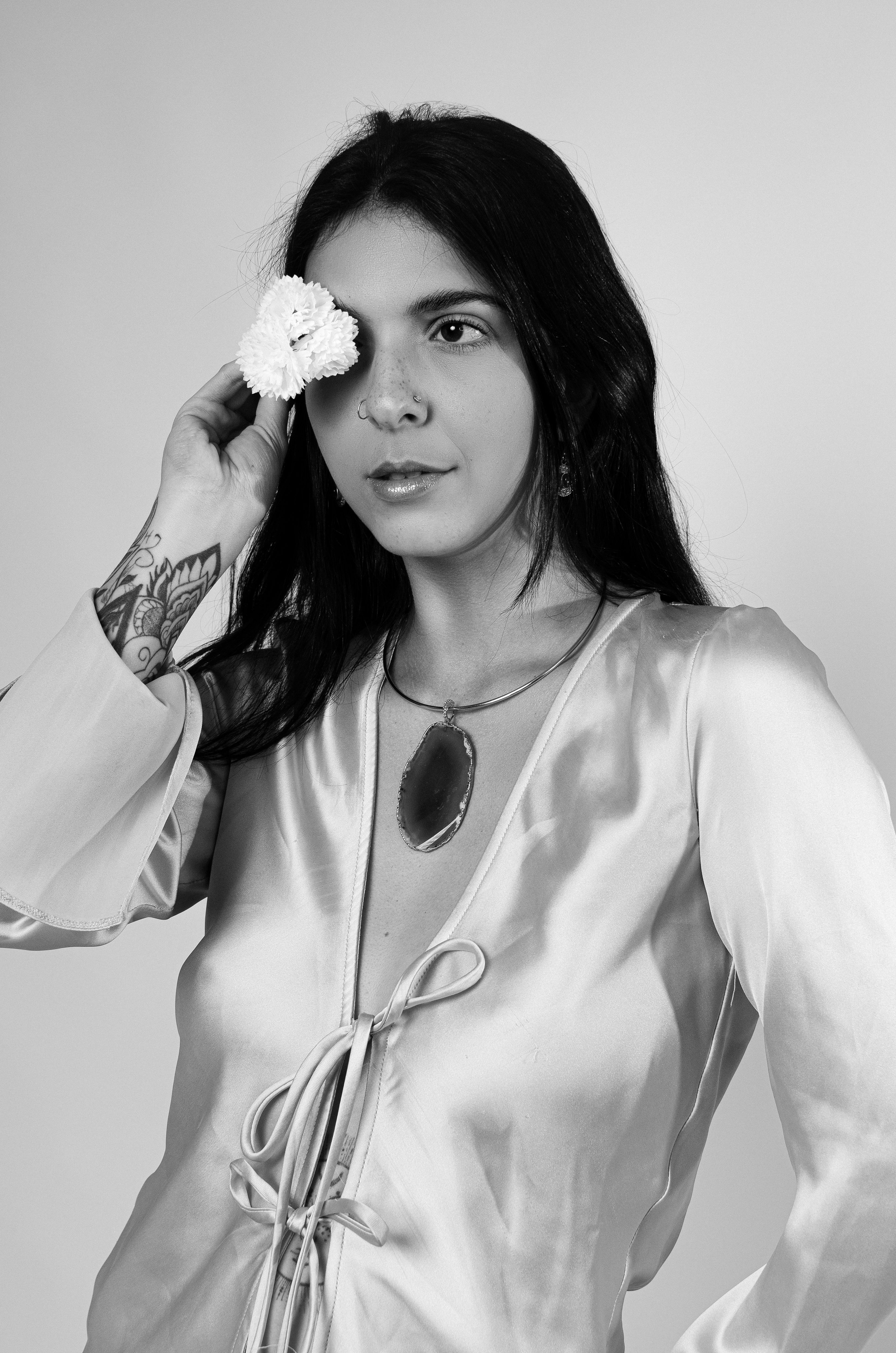 Black and white portrait of a woman with flower, showcasing elegance and style.
