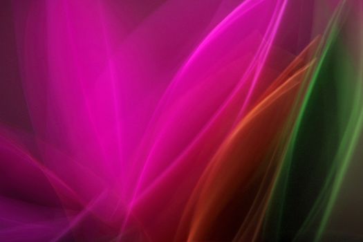 Dynamic abstract image with vibrant pink, green, and orange light streaks creating a mesmerizing visual effect.
