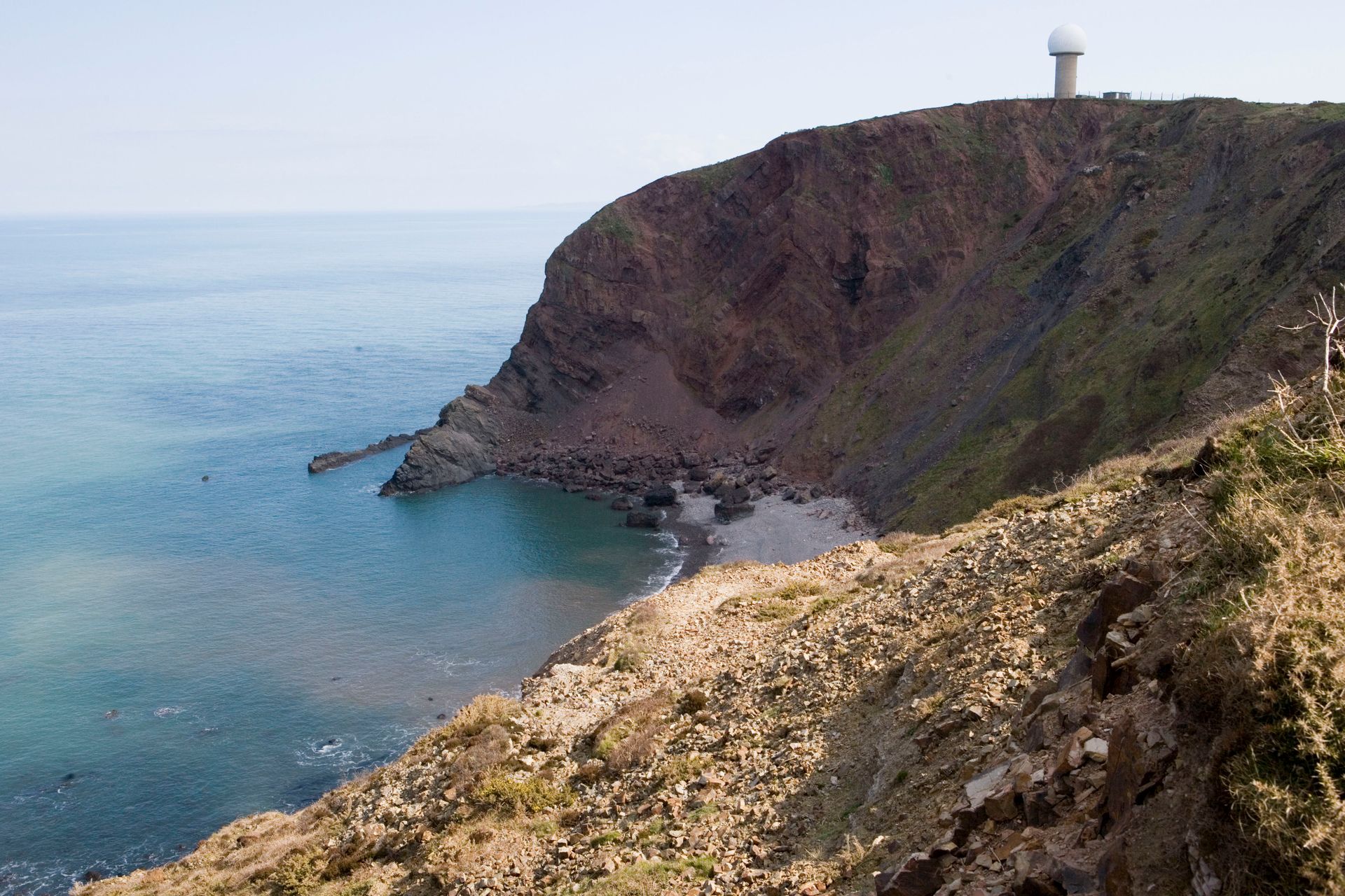 Beautiful cliffside view of the English coastline featuring a radar dome. Ideal for travel enthusiasts.