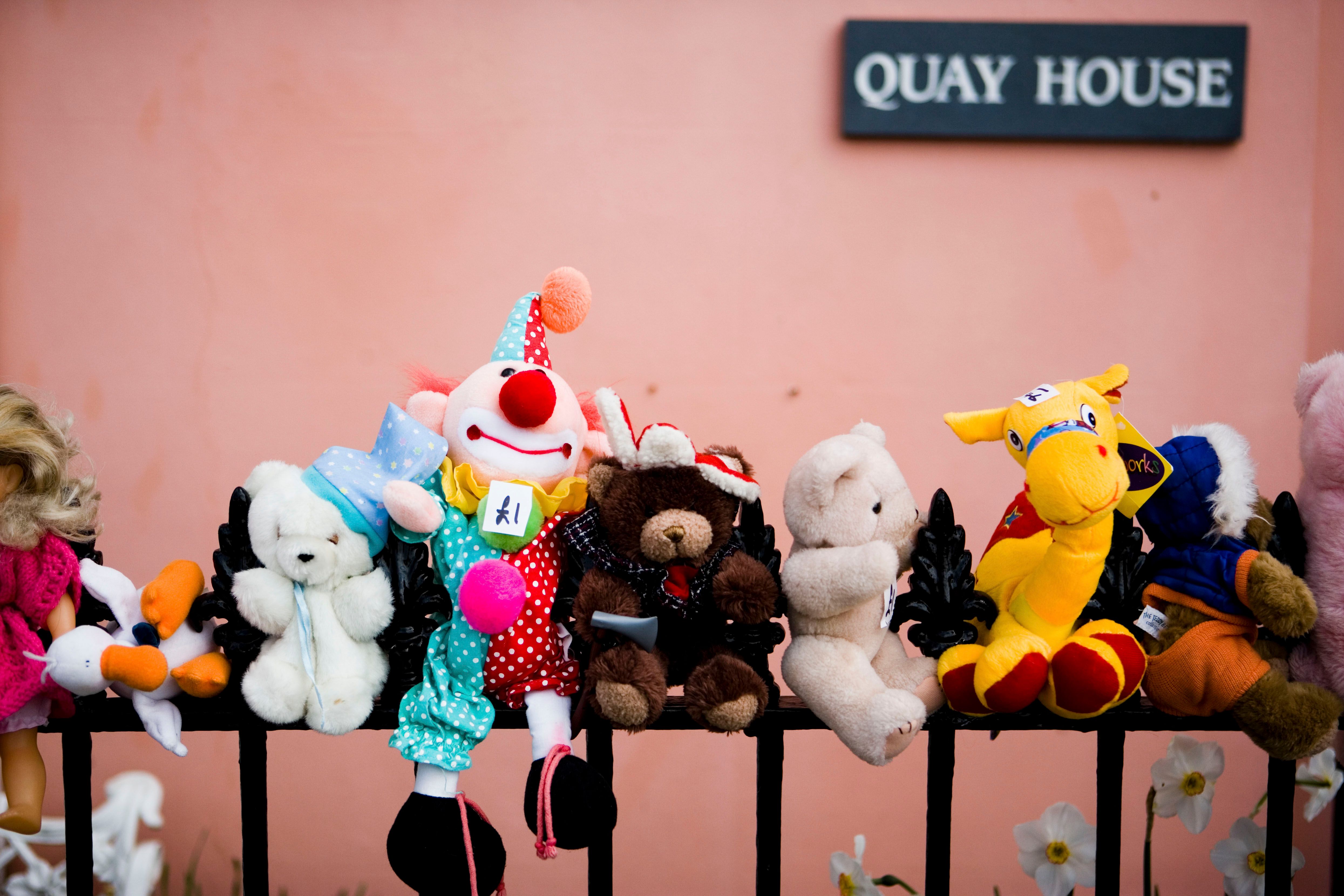 Row of colorful plush toy pets on a shelf