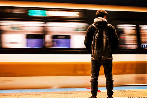 Free A man with a backpack stands as a metro train rushes by at an Istanbul station. Stock Photo