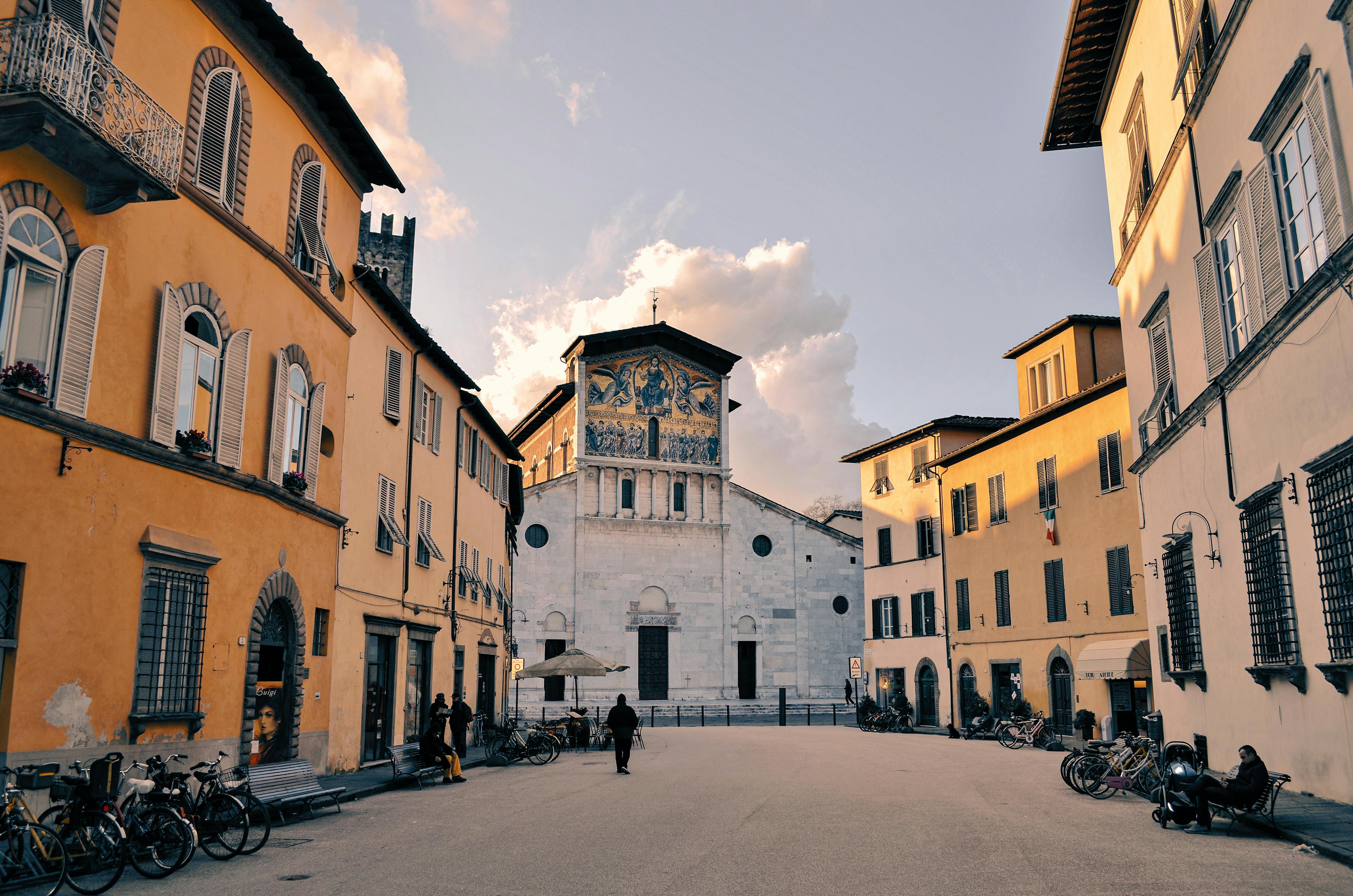 Charming view of Lucca's historic piazza showcasing beautiful Tuscan architecture and a prominent church facade.