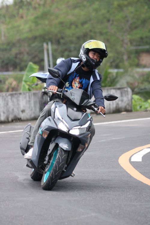 Free A motorcyclist skillfully navigates a curve on a scenic road, showcasing speed and agility. Stock Photo