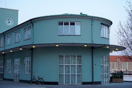 Bauhaus-style building in Copenhagen with clock tower at dusk.