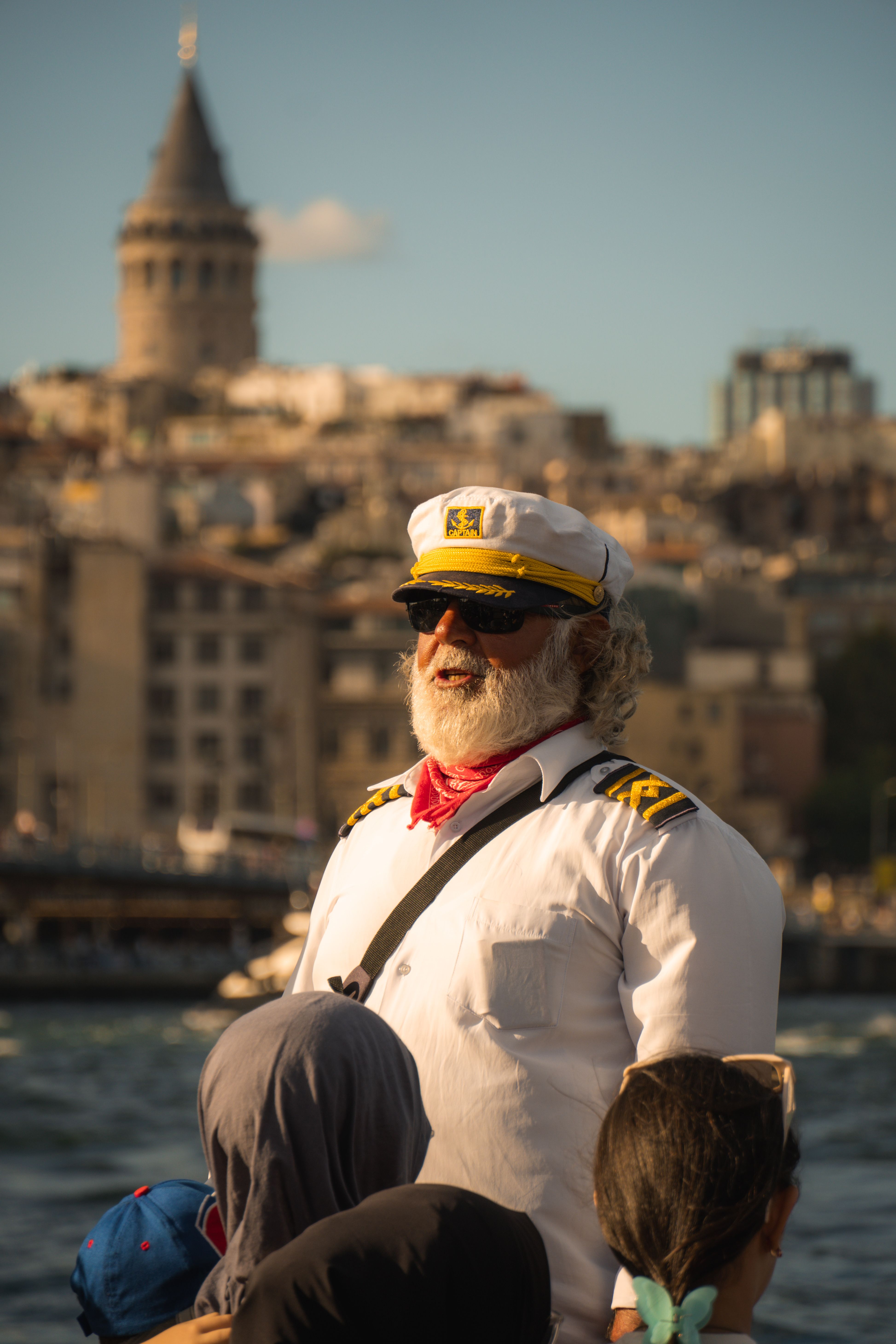 A captain enjoying a sunny day in Istanbul with the Galata Tower visible in the background.