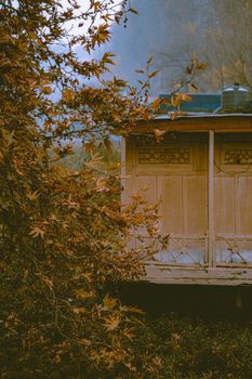 Tranquil autumn landscape featuring a wooden hut surrounded by golden leaves. 29525769