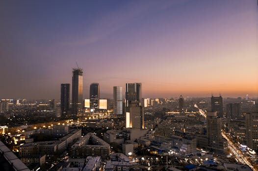 A breathtaking sunset view of a cityscape with high-rise buildings and warm evening lights.