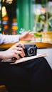Vintage Camera in Hands at Stylish Cafe Setting