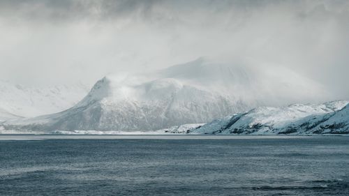 Free Scenic view of snow-capped mountains and ocean in Norway's Arctic region. Stock Photo