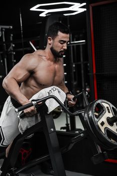 A strong man focuses intensely while lifting weights during workout at the gym.