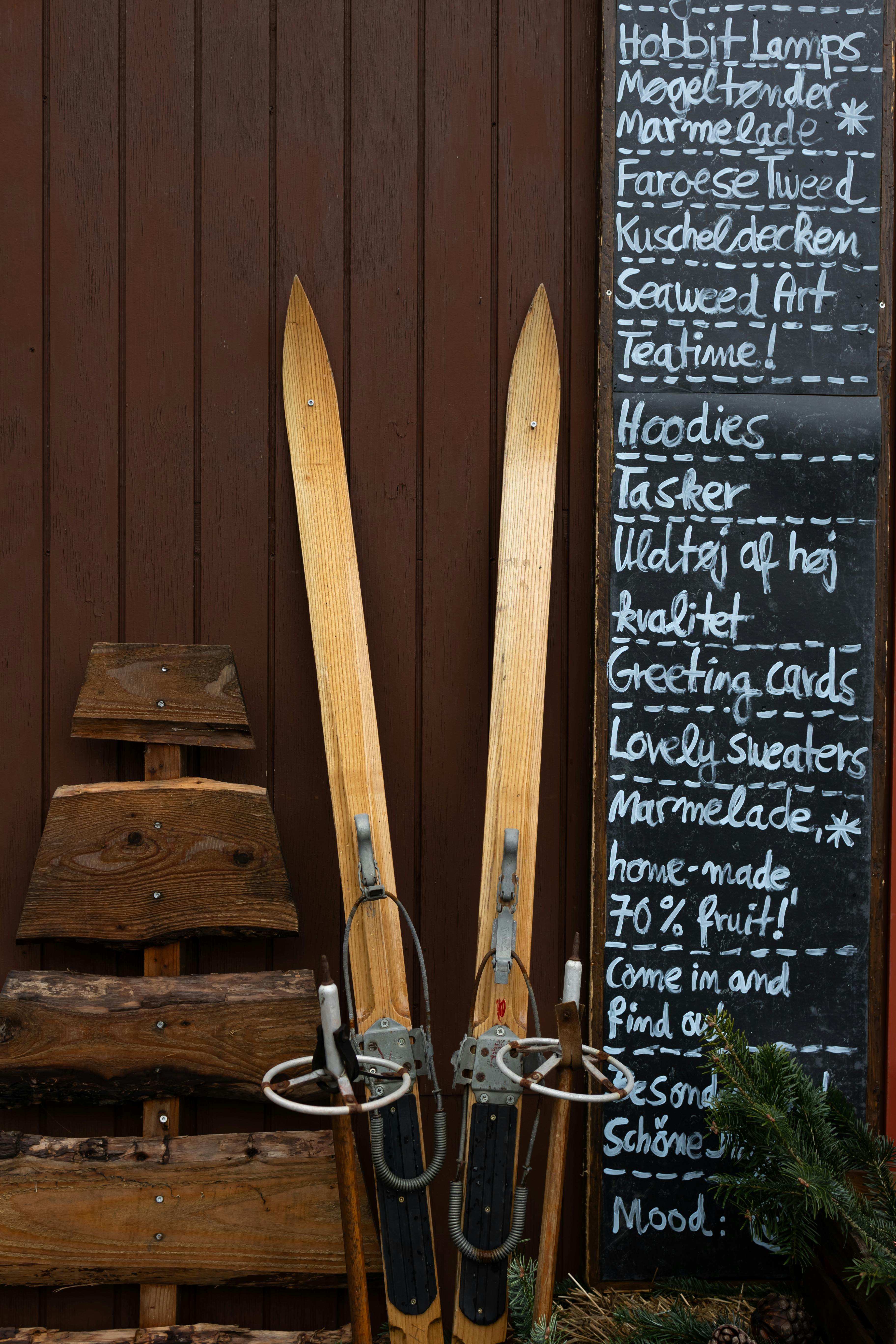 Rustic scene with vintage skis and a chalkboard menu on a wooden wall in Tondern, Denmark.