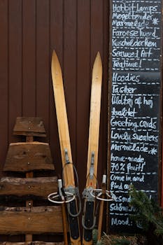 Rustic scene with vintage skis and a chalkboard menu on a wooden wall in Tondern, Denmark.