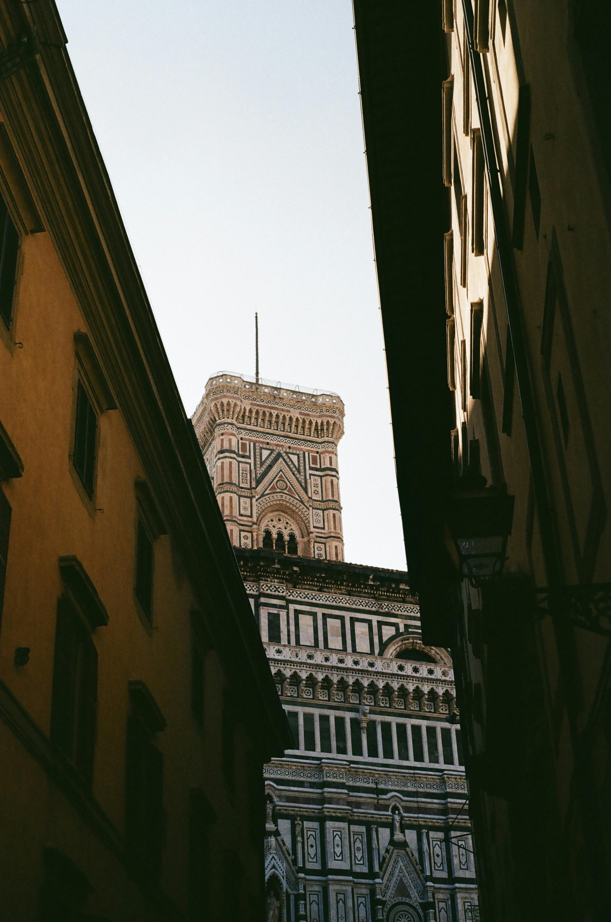 View of Florence Cathedral's bell tower through narrow street, Tuscany.