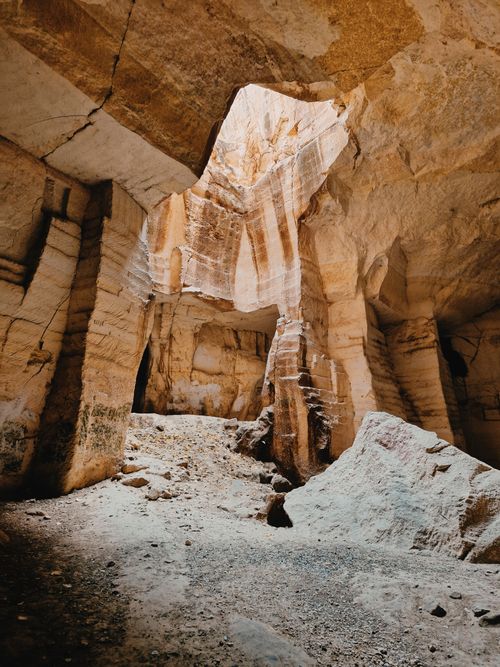 Free Sunlight streams into a tranquil ancient cave with striking rock formations. Stock Photo