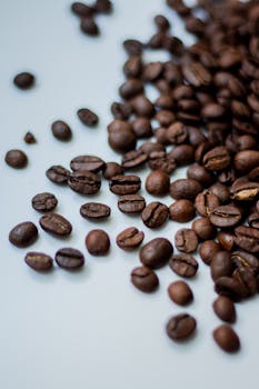A rich and detailed view of roasted coffee beans spread on a white surface.