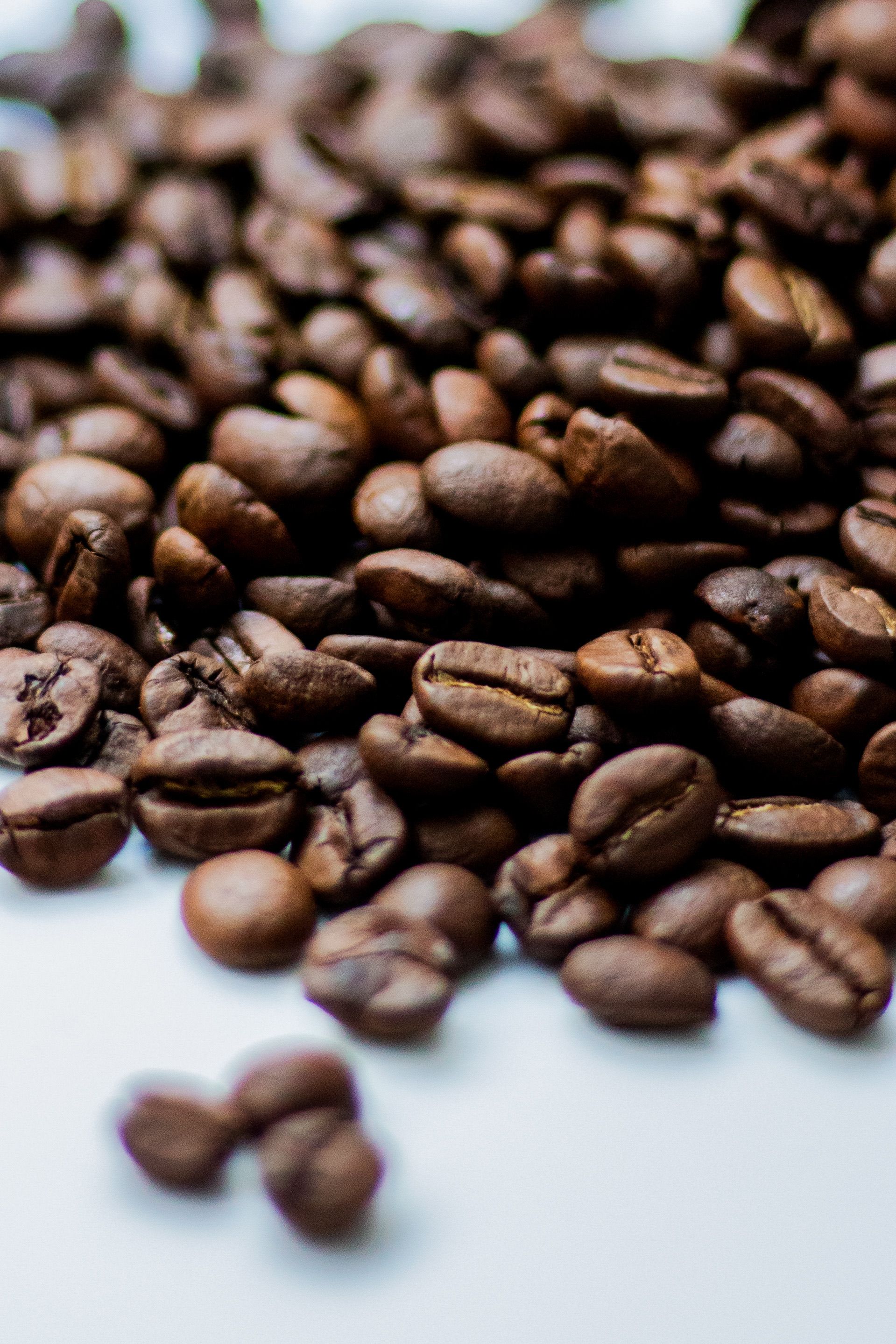 Detailed shot of roasted coffee beans scattered, ideal for coffee themes.