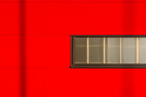 Free A striking minimalist photograph of a red wall featuring a horizontal window. Perfect for modern design inspiration. Stock Photo