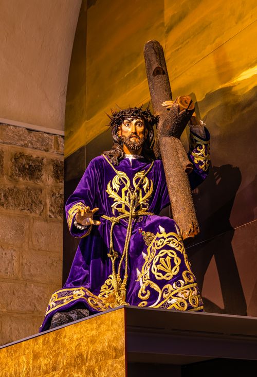 Free Statue of Jesus in León, Spain depicting the carrying of the cross with vibrant robes. Stock Photo