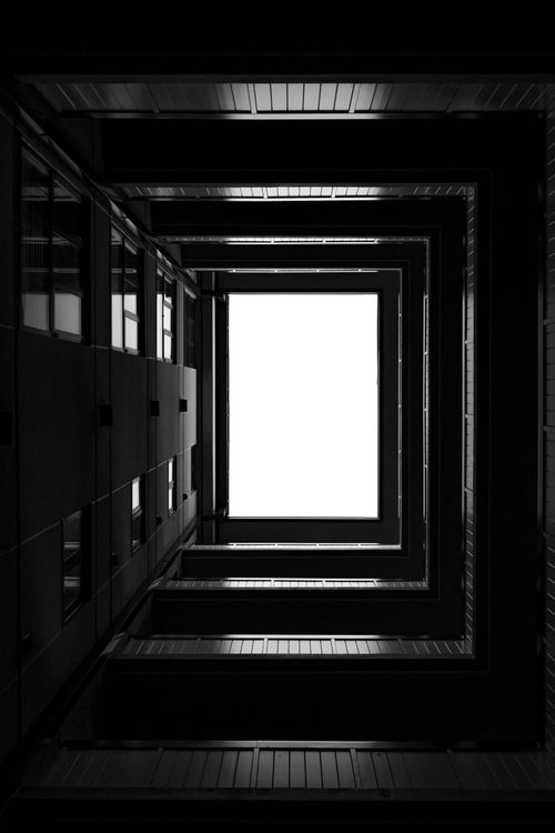 Free Black and white architectural perspective creating geometric patterns with a skylight view. Stock Photo