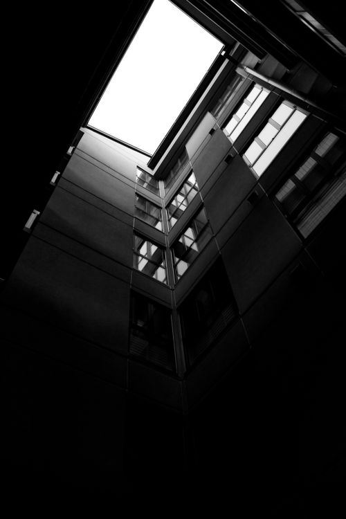 Free Striking black and white perspective of a modern urban building's architecture from below. Stock Photo