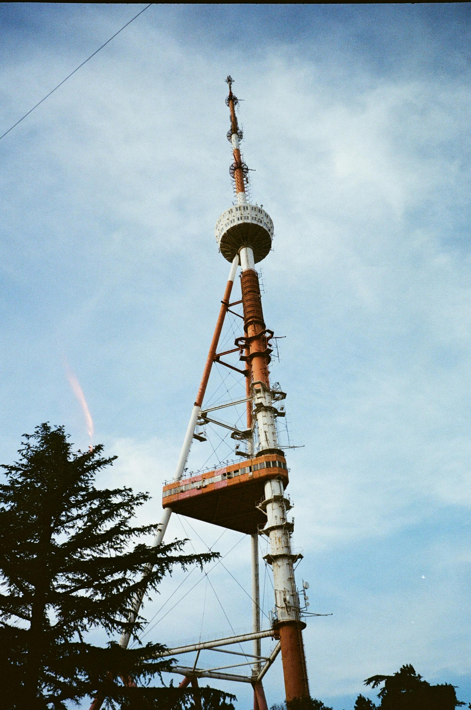A striking view of the iconic Tbilisi TV Tower set against a bright blue sky, symbolizing Georgian communication.