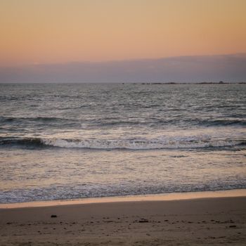 A peaceful sunset over calm ocean waves, creating a serene coastal vibe.