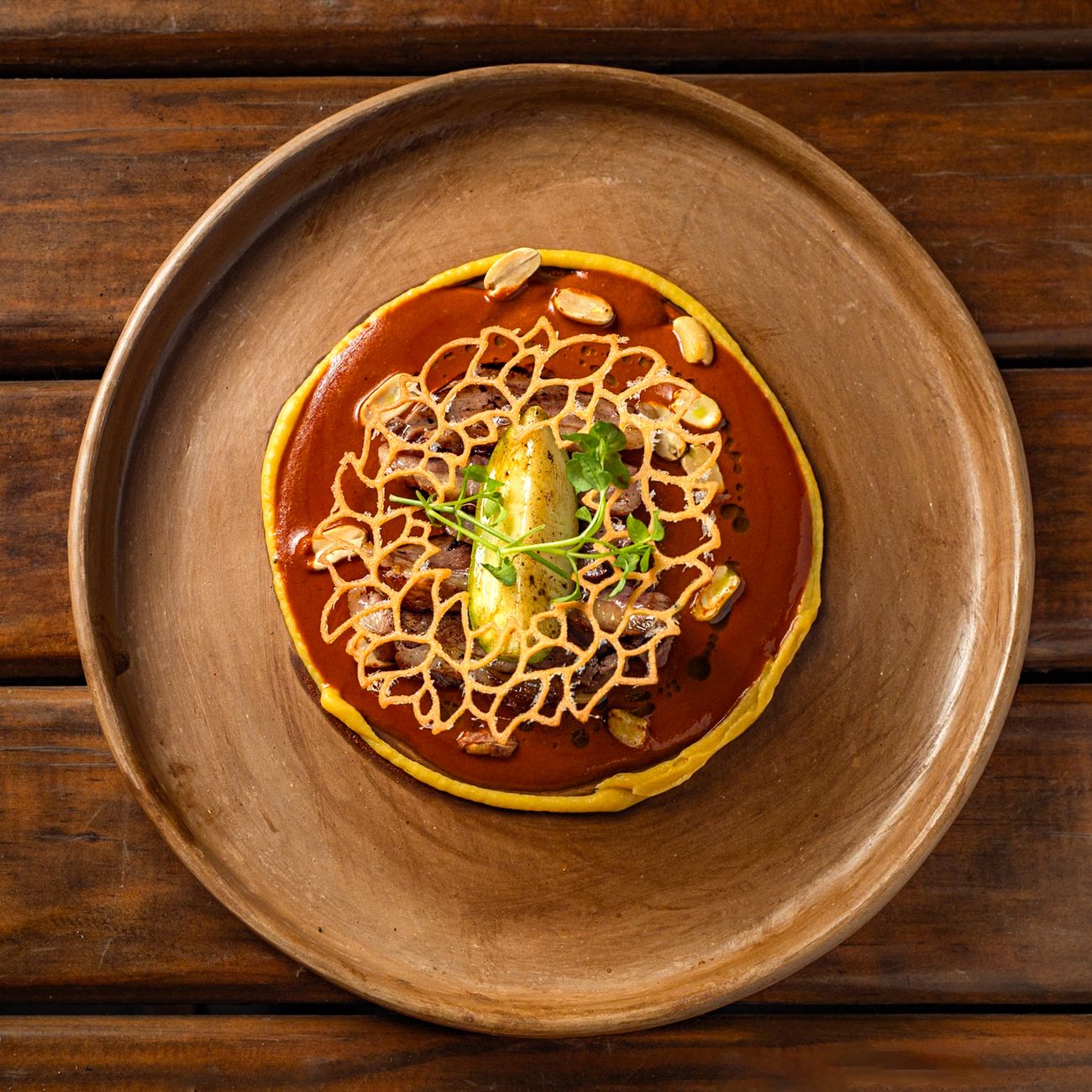 Mole poblano plated over rice with sesame and garnish