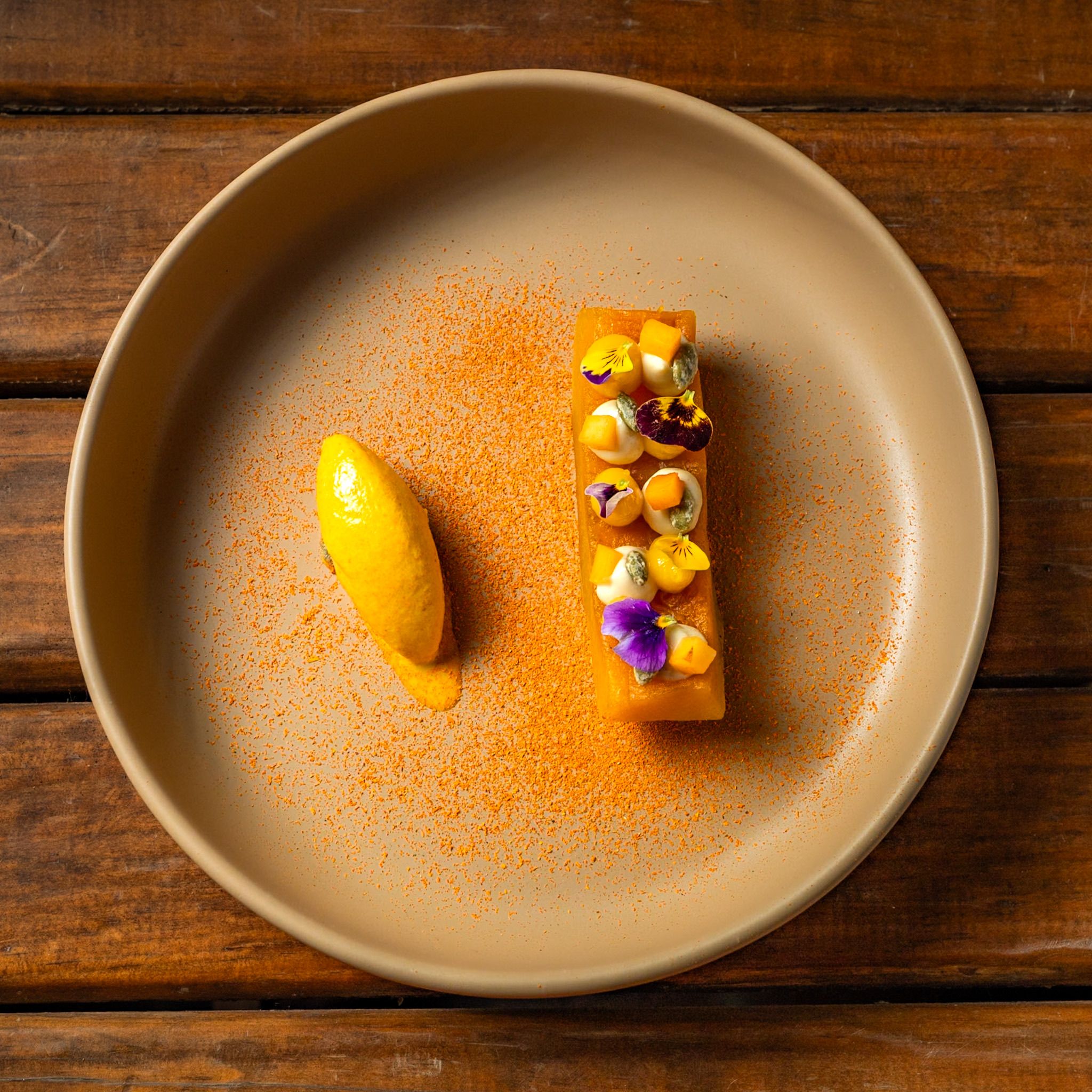 Artistic mango dessert garnished with edible flowers