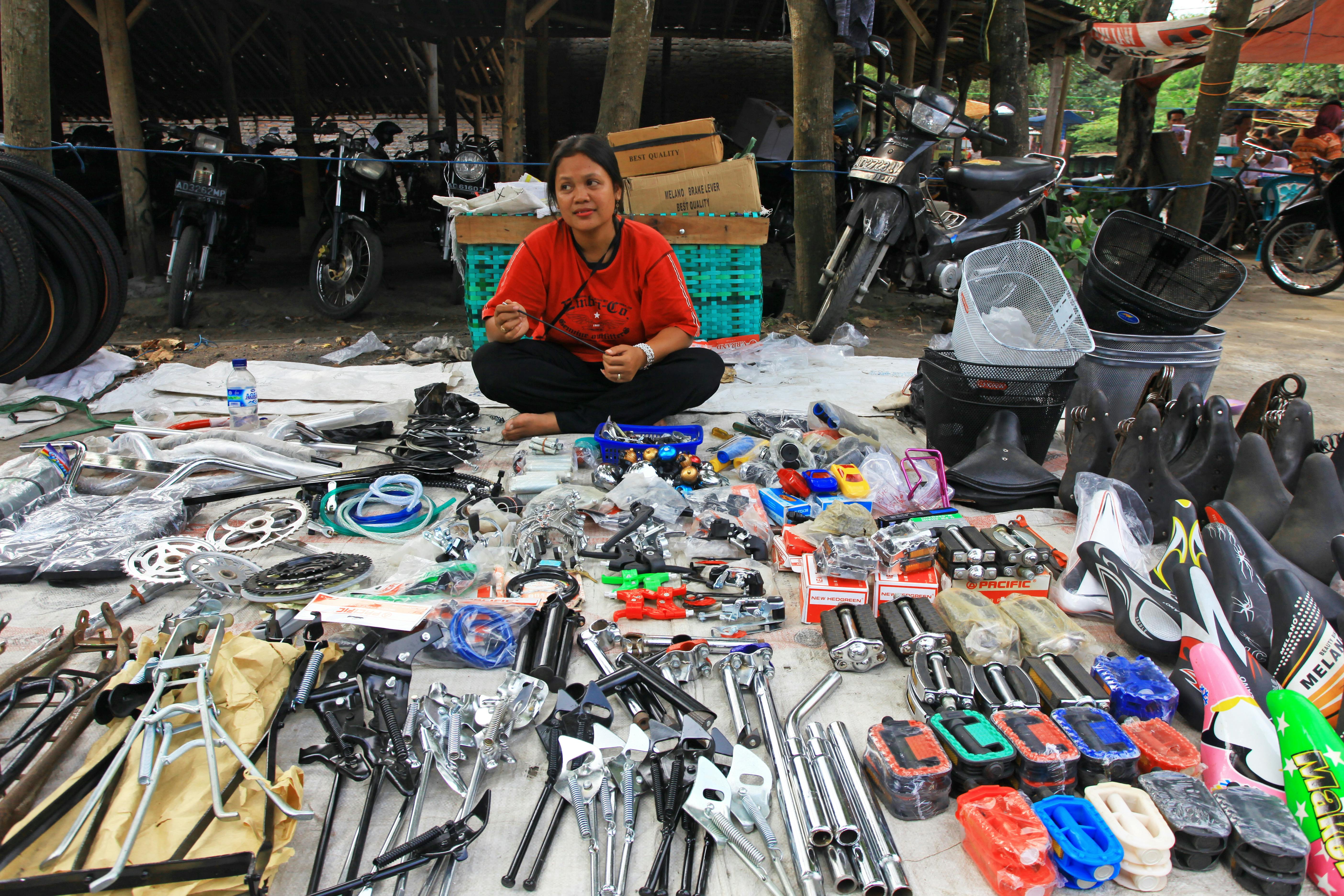 Market vendor displaying an assortment of motorcycle parts at an outdoor market.