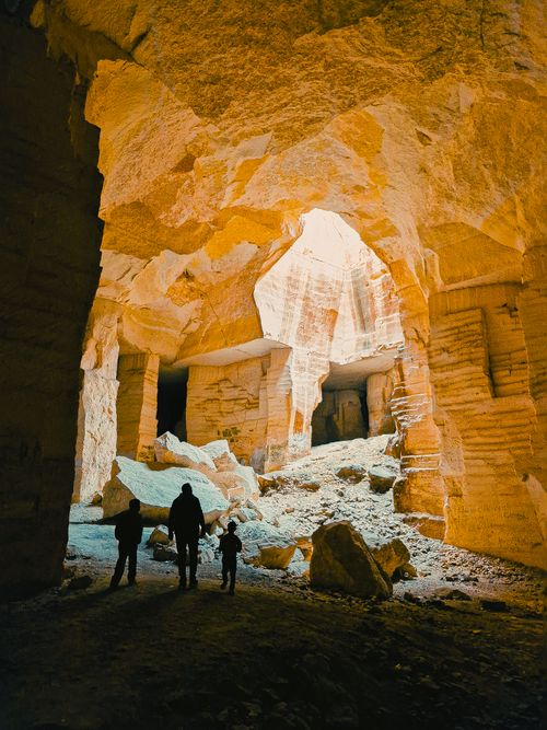 Free Dramatic silhouettes of adventurers in a grand limestone cave, showcasing stunning natural architecture. Stock Photo