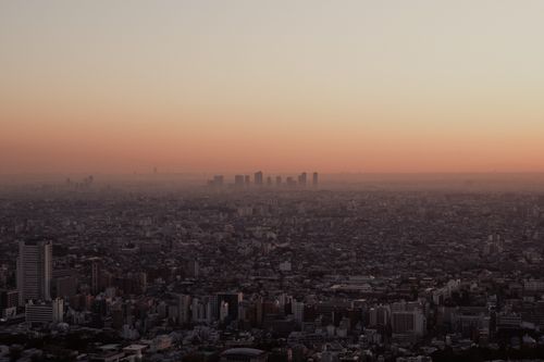 Free Stunning aerial view of Tokyo's skyline at dusk, showcasing a vibrant orange sky and urban landscape. Stock Photo