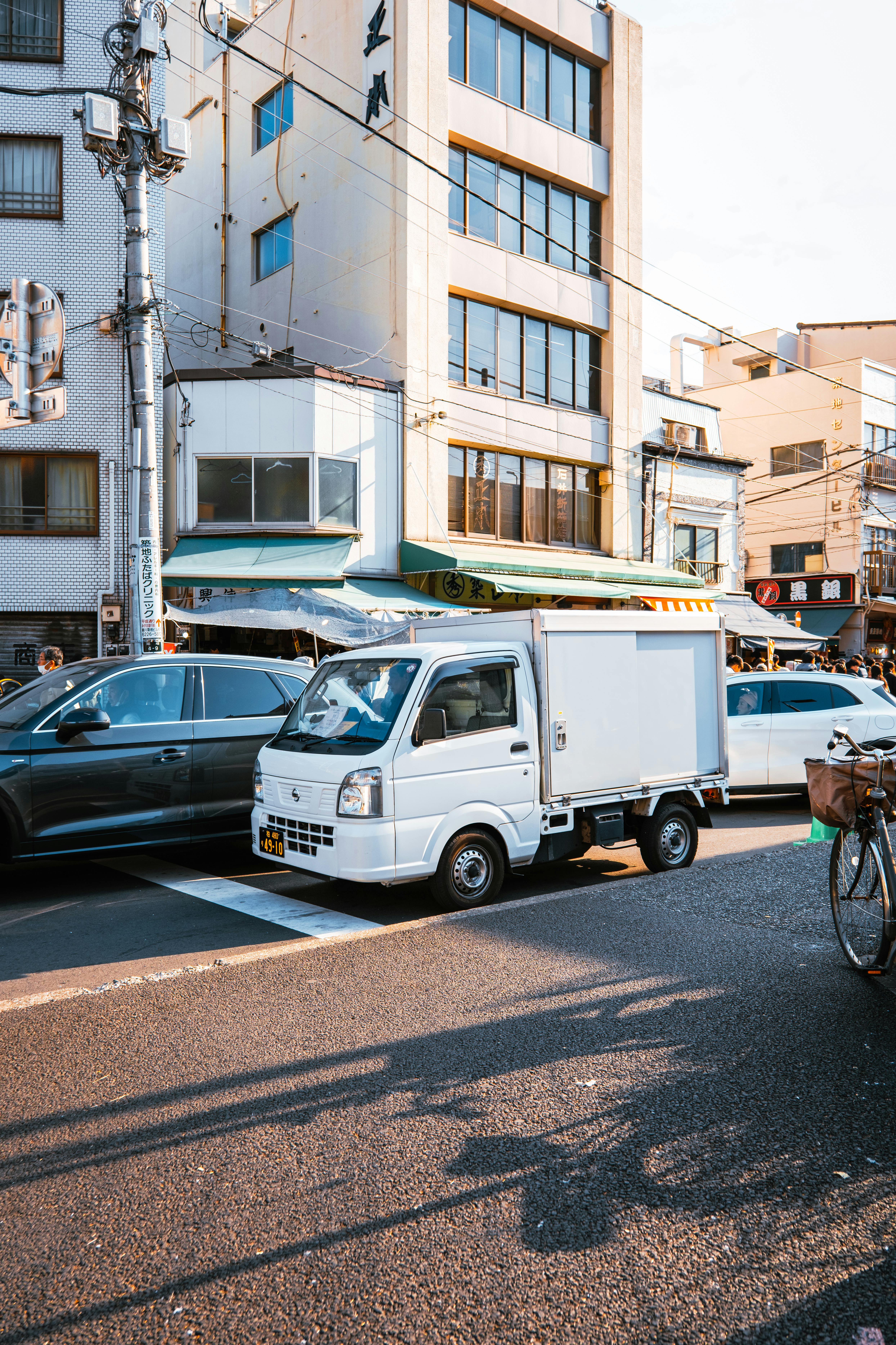 A lively street in Tokyo featuring vehicles and urban architecture.