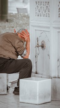 Senior man washing his face at an outdoor marble fountain, signifying refreshment and tradition.