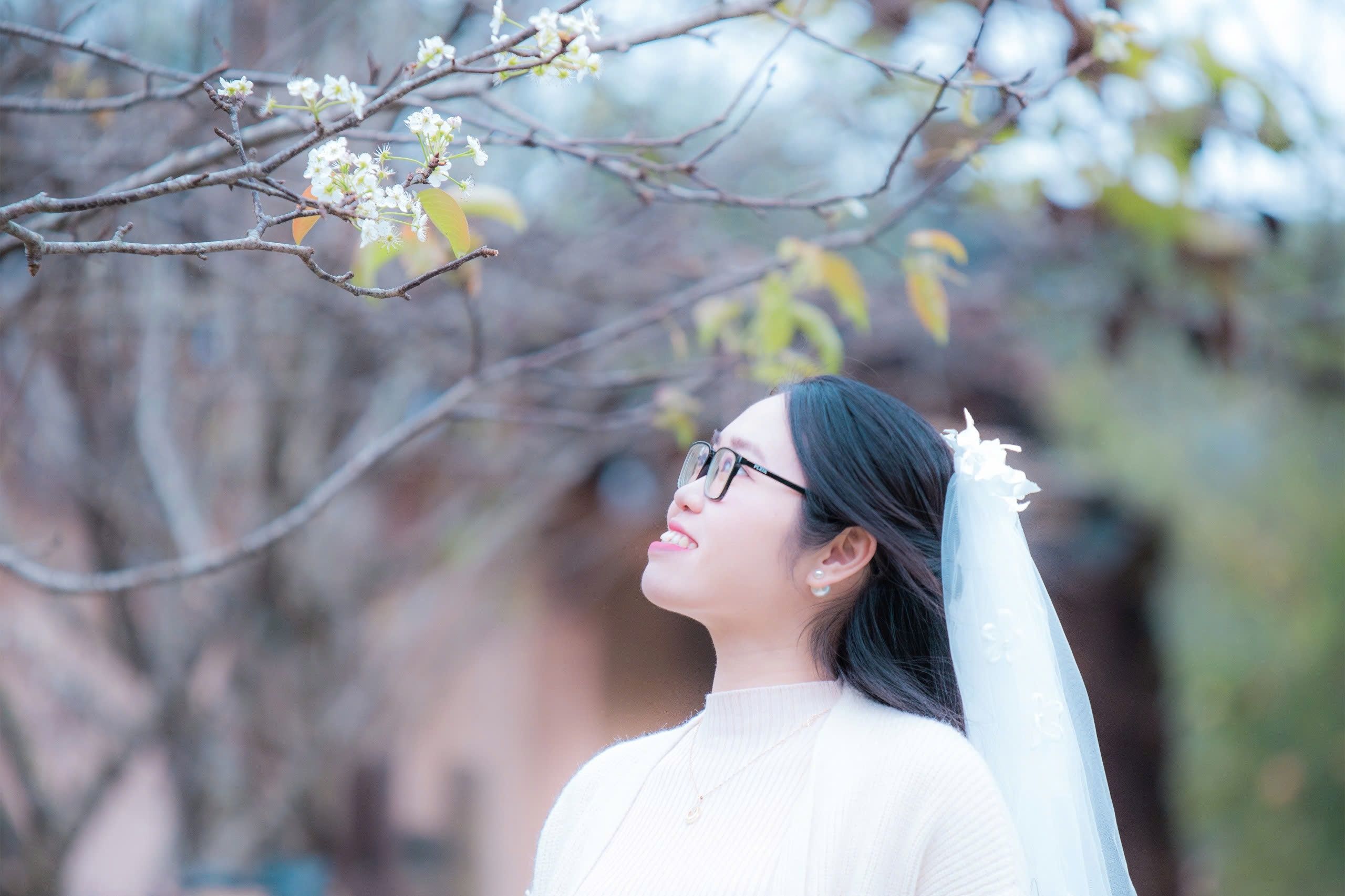 Woman smiling under blossoming spring tree · Free Stock Photo