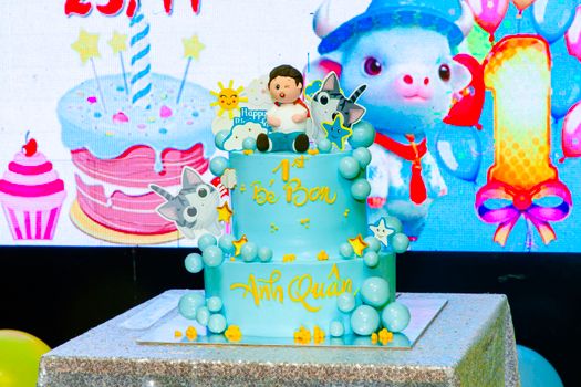 Vibrant 1st birthday cake with cartoon decorations and bright colors.