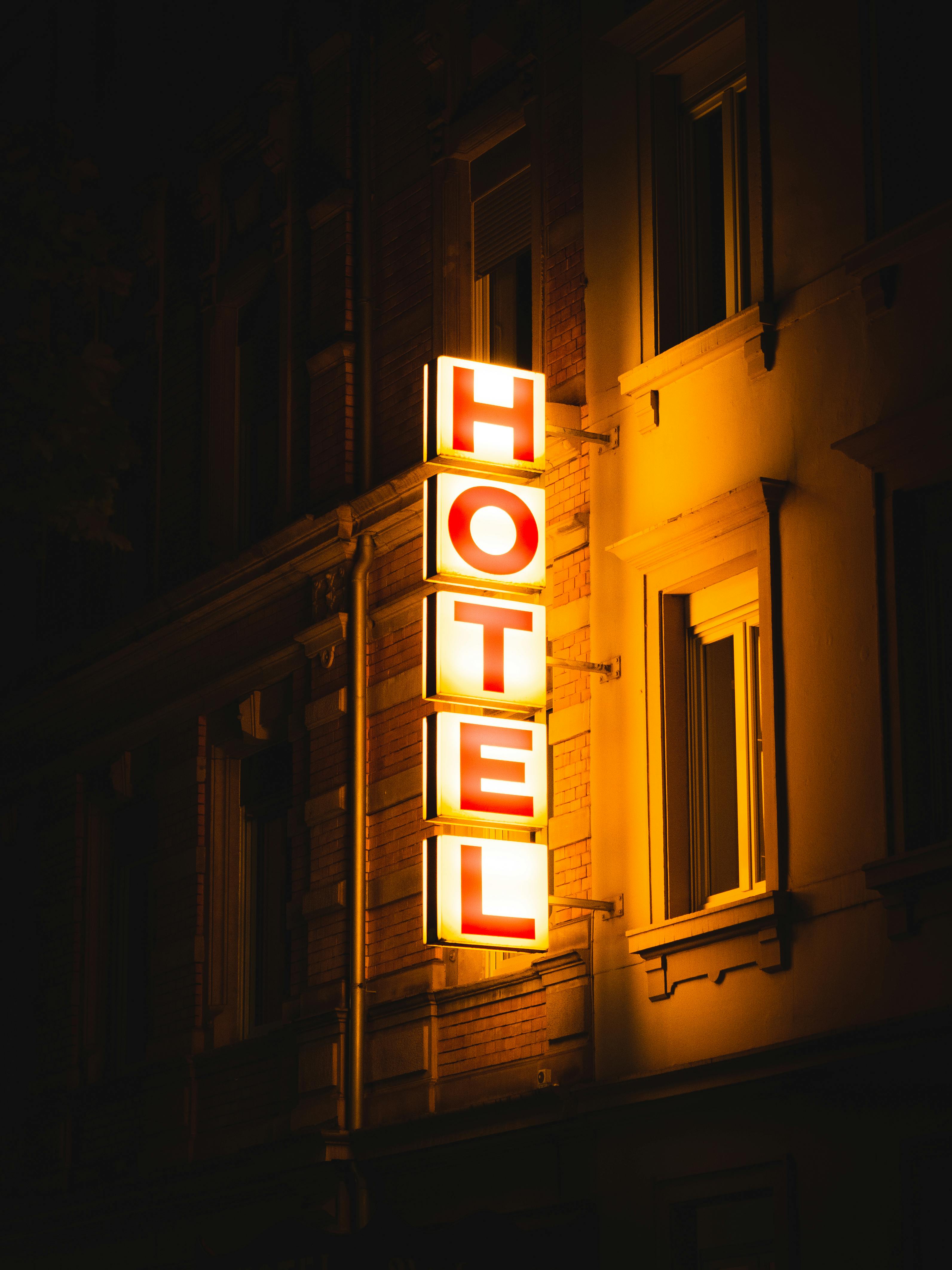 Bright hotel sign glowing on a building in Karlsruhe, Germany, captured at night.