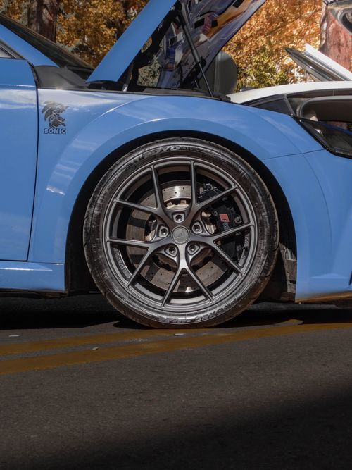 Free Close-up of a blue sports car wheel and open hood outdoors in Ankara, Türkiye. Stock Photo