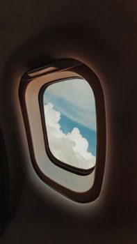 View of clouds through an airplane window; serene sky travel scenery.